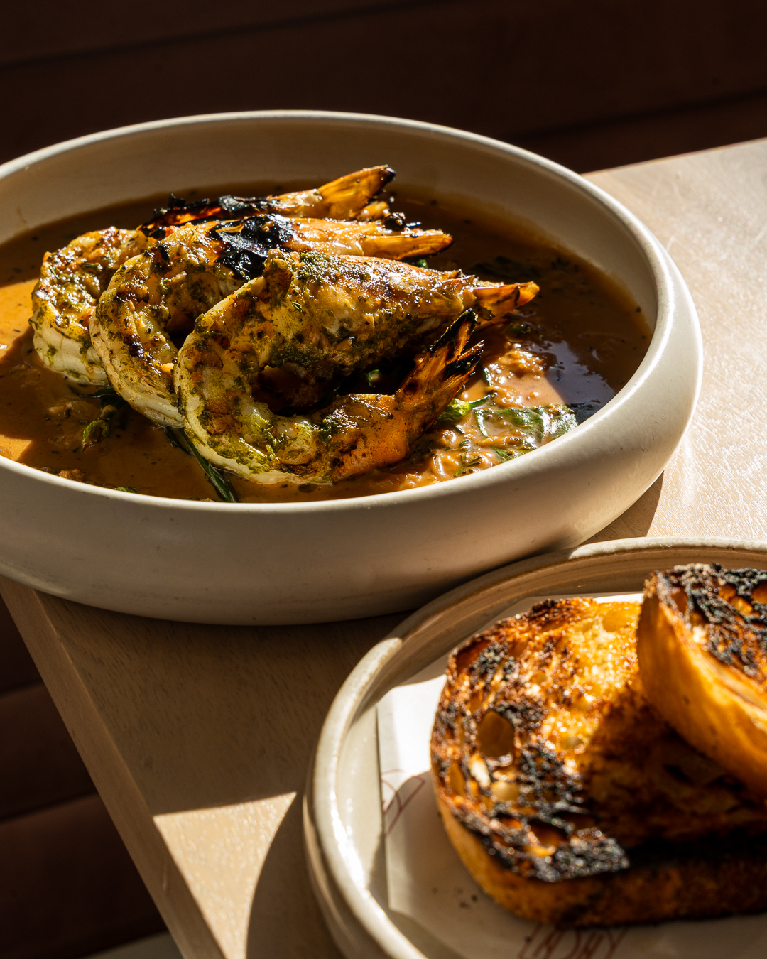 Grilled prawns scampi in a rich broth with charred bread at Ash