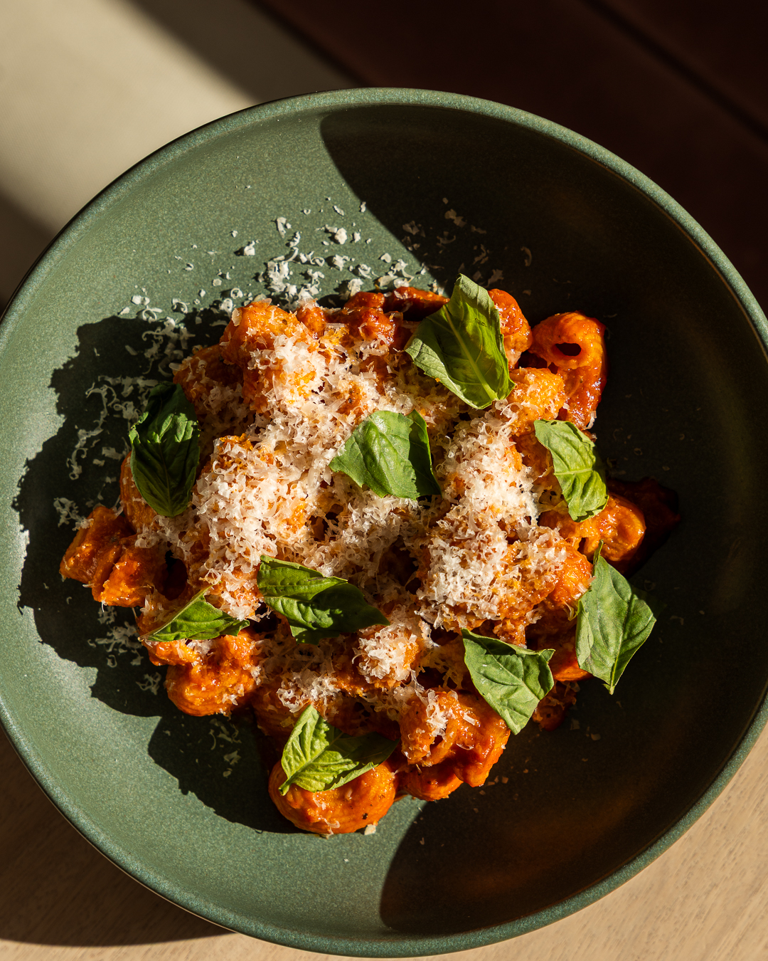 Rigatoni alla vodka topped with grated parmesan and fresh basil leaves